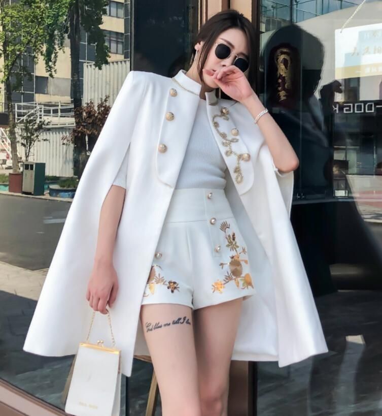 Áo choàng cape dài màu trắng cùng set quần ngắnphong cách tối giản, quyền lực.