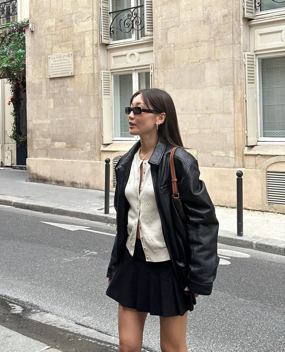 Áo khoác da đen, cardigan trắng, chân váy ngắn đen