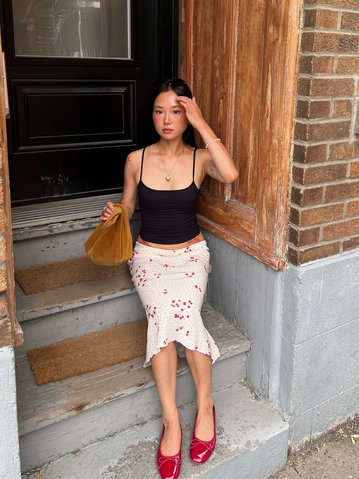 Chân váy mini họa tiết hoa nhí và giày màu đỏ, nhấn nhá bằng phụ kiện