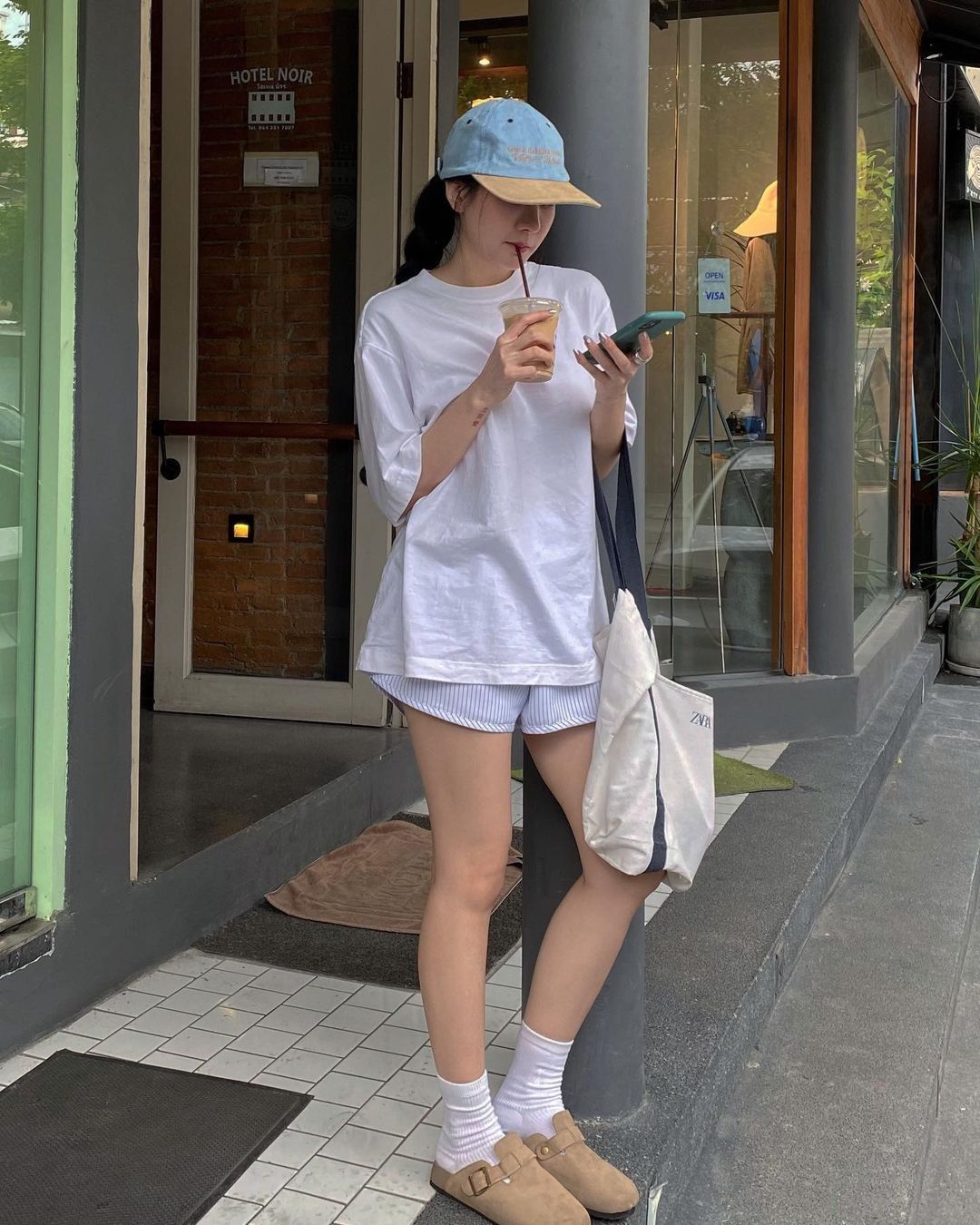 Áo phông rộng, shorts, mũ lưỡi trai, phong cách thoải mái, năng động.